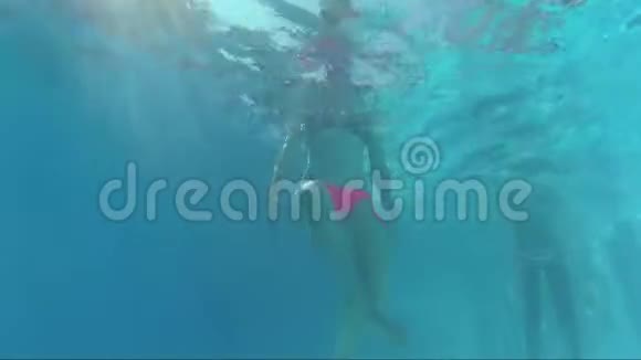 在游泳池底部摆佛姿势的快乐女孩视频的预览图