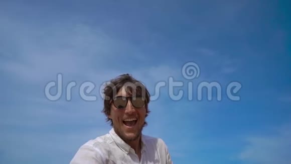 一位快乐的游客在热带海滩上玩得开心一架飞机从他身上飞过视频的预览图
