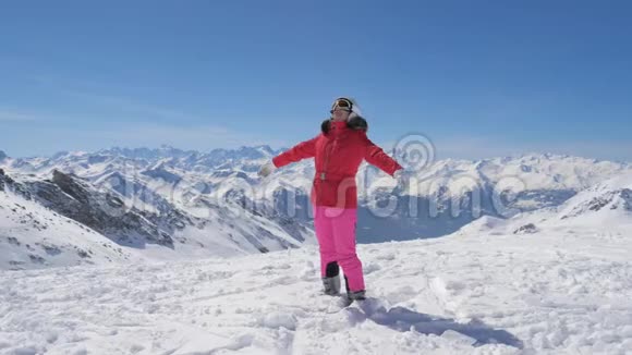 滑雪者女人举起手臂转身然后她在雪山上倒下视频的预览图