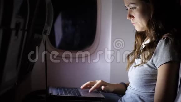 女人在飞机上做笔记本晚上在黑暗的飞机沙龙视频的预览图