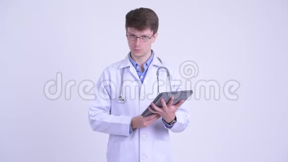 快乐的年轻医生一边讲一边显示数字平板电脑视频的预览图