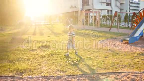 日落时分可爱的幼儿男孩在公园操场上奔跑视频的预览图