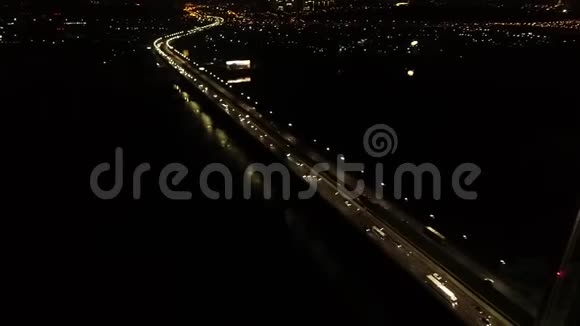 美丽的夜晚城市和一座巨大的桥梁许多汽车发光的灯光空中射击视频的预览图