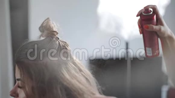 发饰喷向女人头发在美容院制作发型的过程视频的预览图