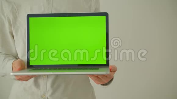 室内办公室里男性手拿着绿色屏幕的笔记本电脑的特写镜头视频的预览图