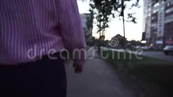 在人行道上行走的一名身穿正式服装的不明女子的后景视频的预览图