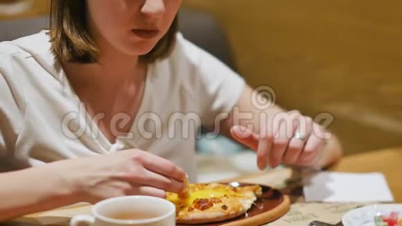 女人在一家有白种人美食的餐馆吃午饭特写镜头女人吃热汁多的卡查普里蘸一块视频的预览图
