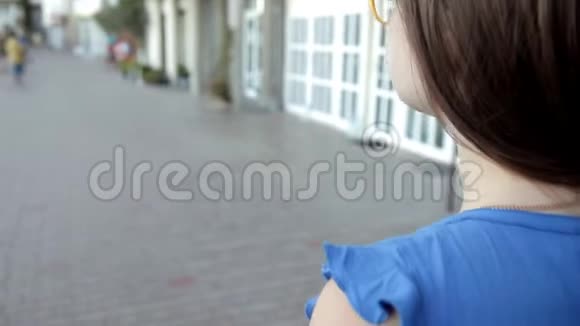 一个年轻的女孩走过位于海边的城市休息散步视频的预览图