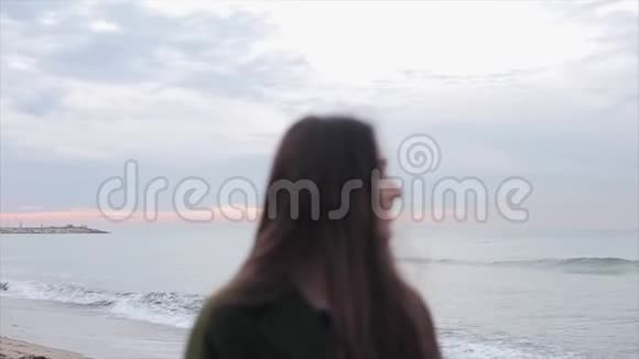 一幅美丽的女孩的半身肖像她的长发乌黑的头发向左看站在海滨视频的预览图