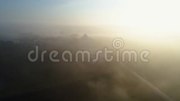 在阳光明媚的早晨用雾覆盖田野的空中景观视频的预览图
