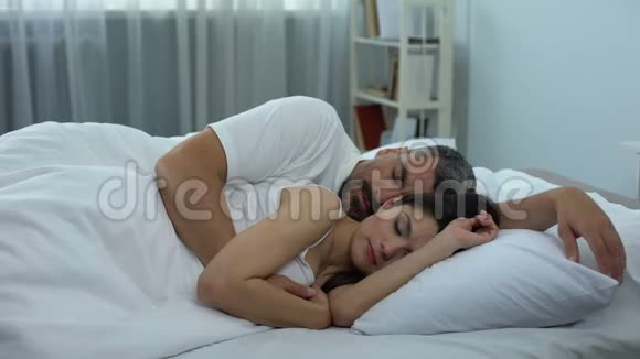 漂亮的一对夫妇安静地睡在舒适的床上骨科放松解决方案视频的预览图