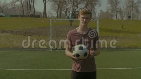 微笑少年手持足球的肖像视频的预览图