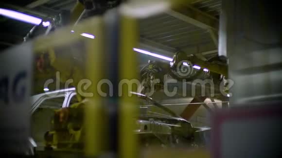 围栏后面的视角机器人手臂焊接汽车金属车身视频的预览图