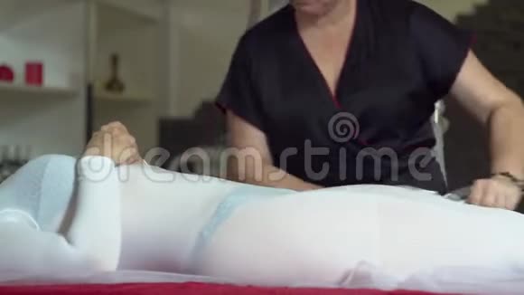 女孩在美容院做液化石油气按摩美容师为病人做抗纤维素按摩视频的预览图
