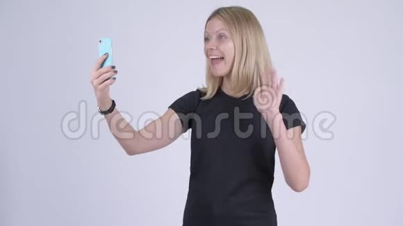 年轻快乐的金发女人视频通话显示电话视频的预览图