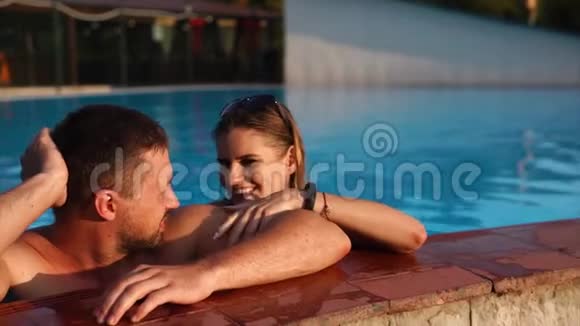 年轻夫妇正一起在游泳池里游泳视频的预览图