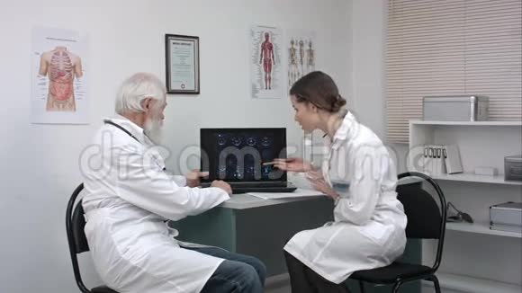 在笔记本电脑上讨论病人扫描的医生视频的预览图