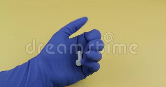 穿着蓝色医用手套的白色药丸女人吃了一片药视频的预览图