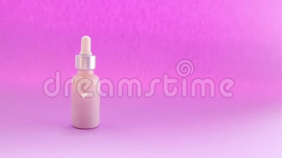 女性手拿化妆品吸管与天然补救在玻璃瓶上的粉红色背景视频的预览图