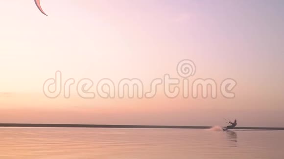 一个戴着照相机头盔的人在黎明时从事风筝冲浪动作缓慢视频的预览图