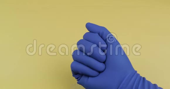穿着蓝色医用手套的白色药丸女人吃了一个椭圆形的药丸视频的预览图