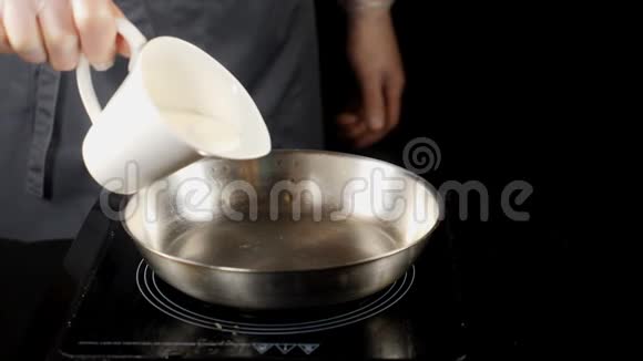 专业的工作理念精致的餐饮理念厨师手套把奶油倒入煎锅把奶油酱放在视频的预览图
