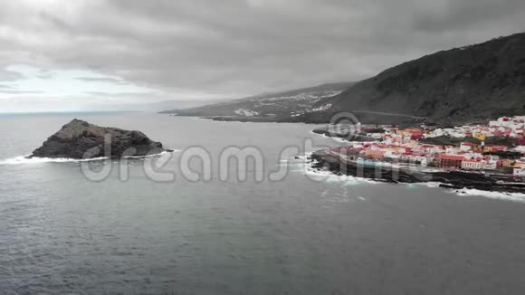空中射击山底的小镇海洋的火山岸海上的石岛海浪拍打视频的预览图