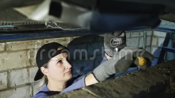 可爱的女机械师在机库里修理一辆车视频的预览图