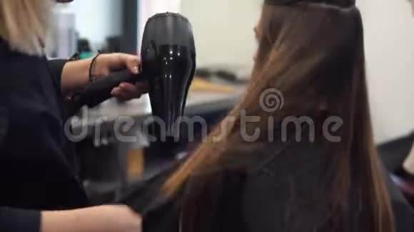 发廊上幸福女人的肖像专业发型造型理念理发师吹干头发的女孩视频的预览图