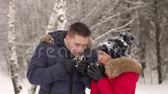 恋爱中的情侣在冬季公园喝热茶视频的预览图