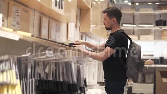 一名男性购物者正在商场的一家商店检查厨房刀具视频的预览图