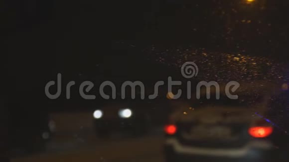 晚上掉在汽车挡风玻璃上带着闪烁的灯光路过救护车视频的预览图
