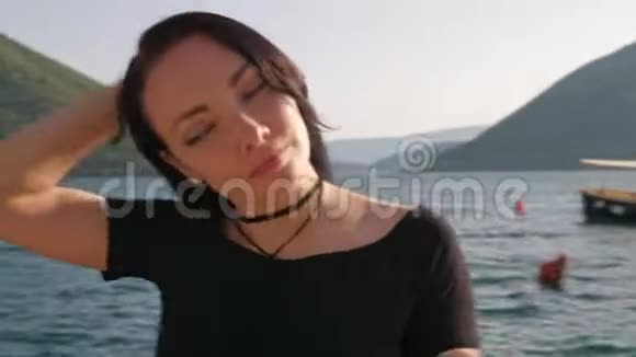 一位年轻女子在海边和群山中的特写镜头视频的预览图