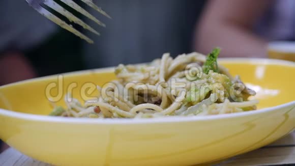 吃意大利面食有帕尔马干酪鳄梨和培根慢动作特写视频的预览图