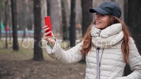 在公园用智能手机打视频电话的年轻女子视频的预览图