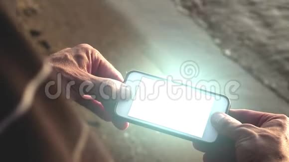 闪烁的未来智能手机被人在海滩科技概念视频的预览图
