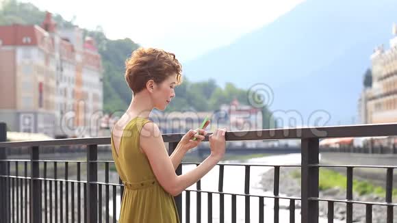 一位美女在城市背景下的智能手机上自拍旅游游客夏季视频的预览图