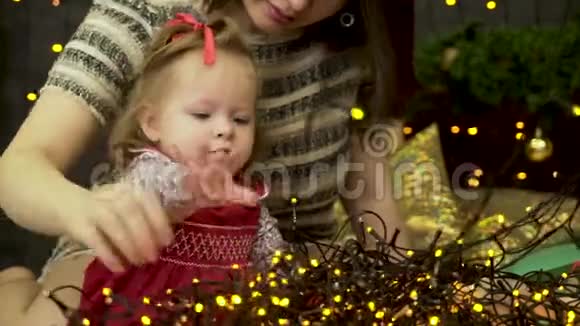 快乐的家庭妈妈和小女儿在冬天玩圣诞假期闪闪发光的背景视频的预览图