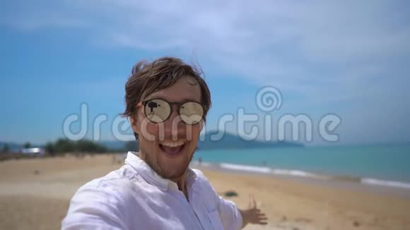 一位快乐的游客在热带海滩上玩得开心一架飞机从他身上飞过视频的预览图