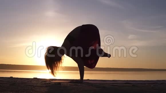 瑜伽巴卡萨纳起重机由妇女的轮廓与阴霾日落天空背景视频的预览图