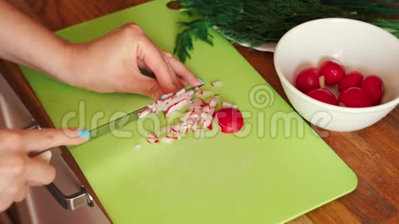 女人正在木桌上切厨房里的新鲜萝卜视频的预览图
