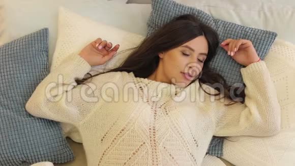 怀孕的女孩穿着温暖的毛衣睡在床上视频的预览图