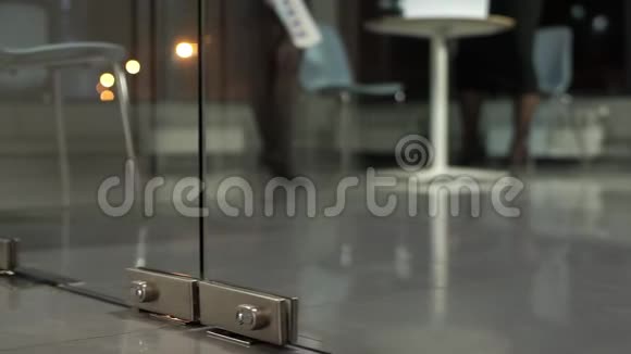 一扇玻璃门打开男人黑鞋走进办公室视频的预览图
