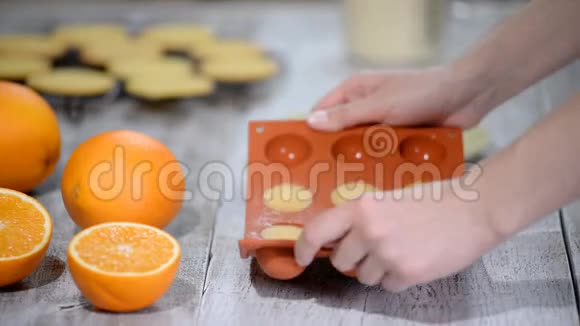 手拿橙色填充从一个灵活的硅胶模具视频的预览图