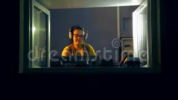 收音机里戴着耳机的女DJ在混合控制台拿着迪斯科视频的预览图
