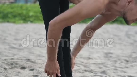 关闭男性做瑜伽和伸展运动在沙滩视频的预览图