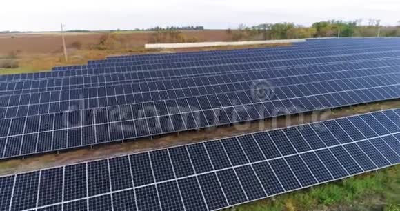 从上面可以看到太阳能发电站在森林附近的一个大型太阳能发电站上空飞行视频的预览图