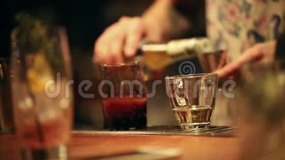 酒保在工作混合一种酒精鸡尾酒测定酒精含量并在玻璃杯中加入一种成分视频的预览图