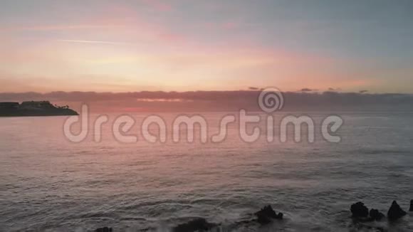 空中射击日出在海洋上空粉红色和橙色海洋岛火山岩从熔岩中喷出视频的预览图