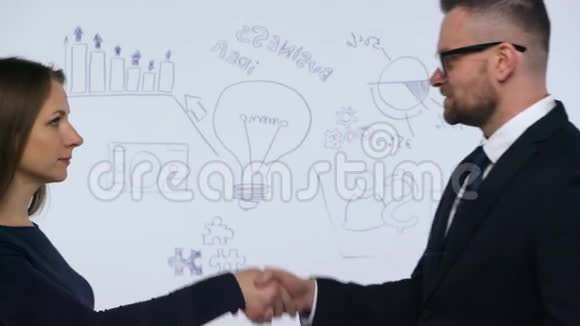 男人和女人握手讨论在现代玻璃办公室成功的商业策略视频的预览图